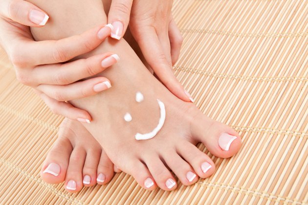 Woman moisturizing feet