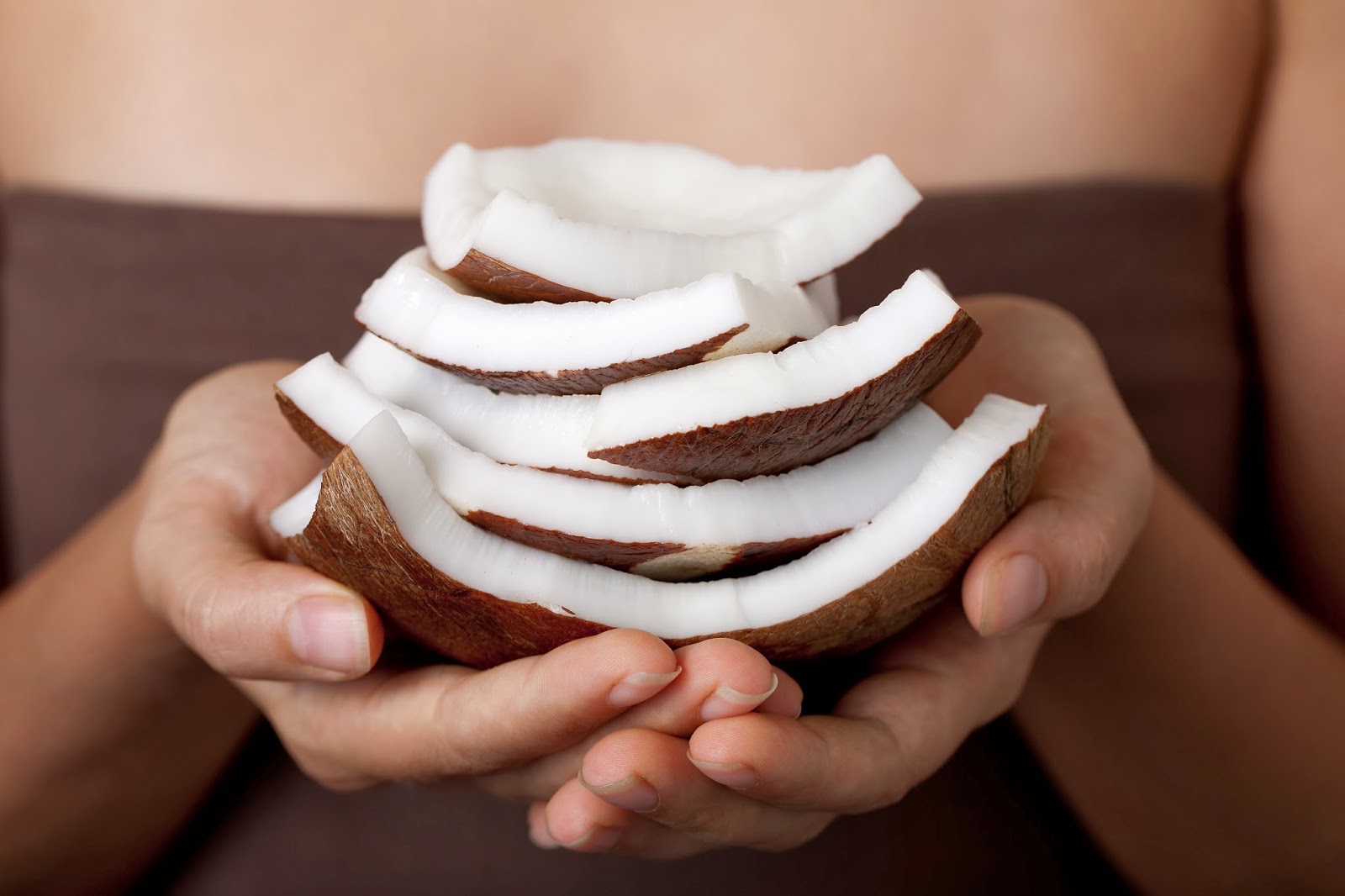Female hands holding slices of coconut