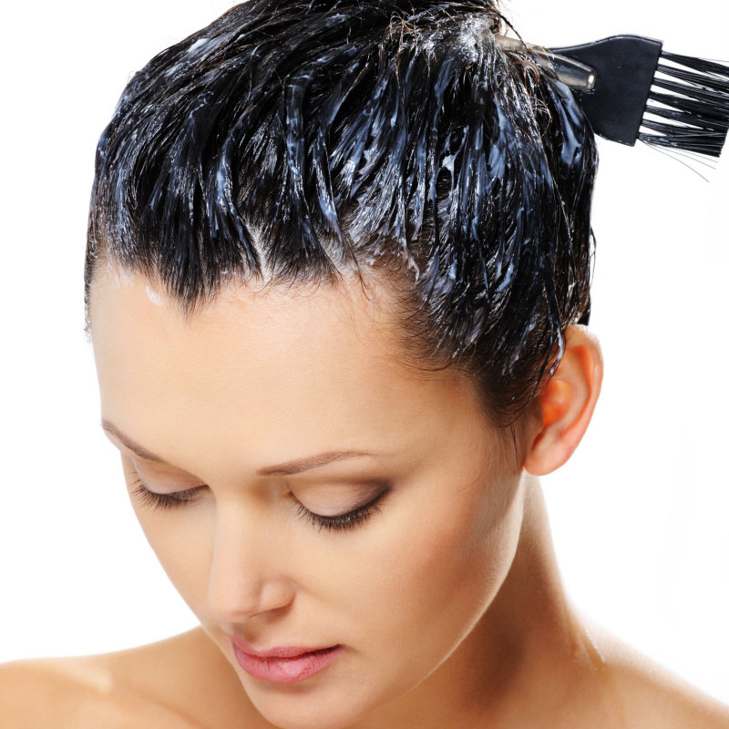 Hair coloring treatment on woman's dark hair