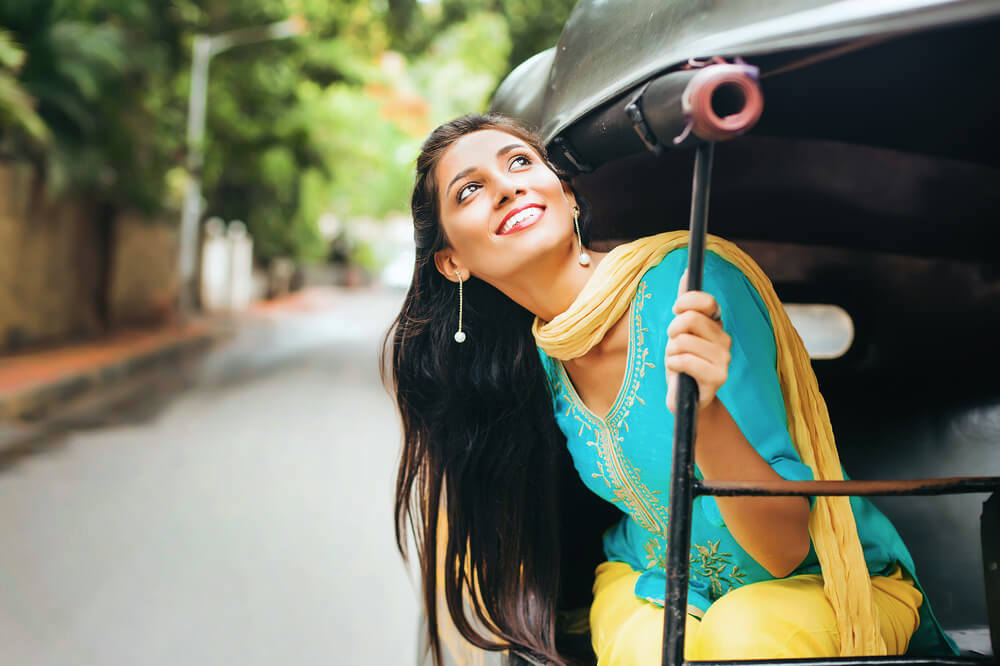 Happy single woman enjoying life from a rickshaw 