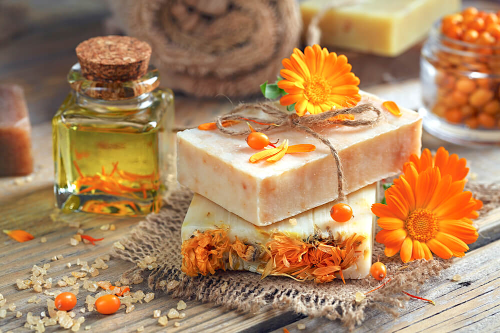 Natural soap on table surrounded by flower petals