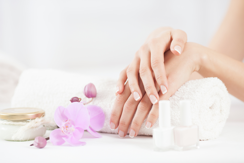 Female hands with nail polish and flower petals