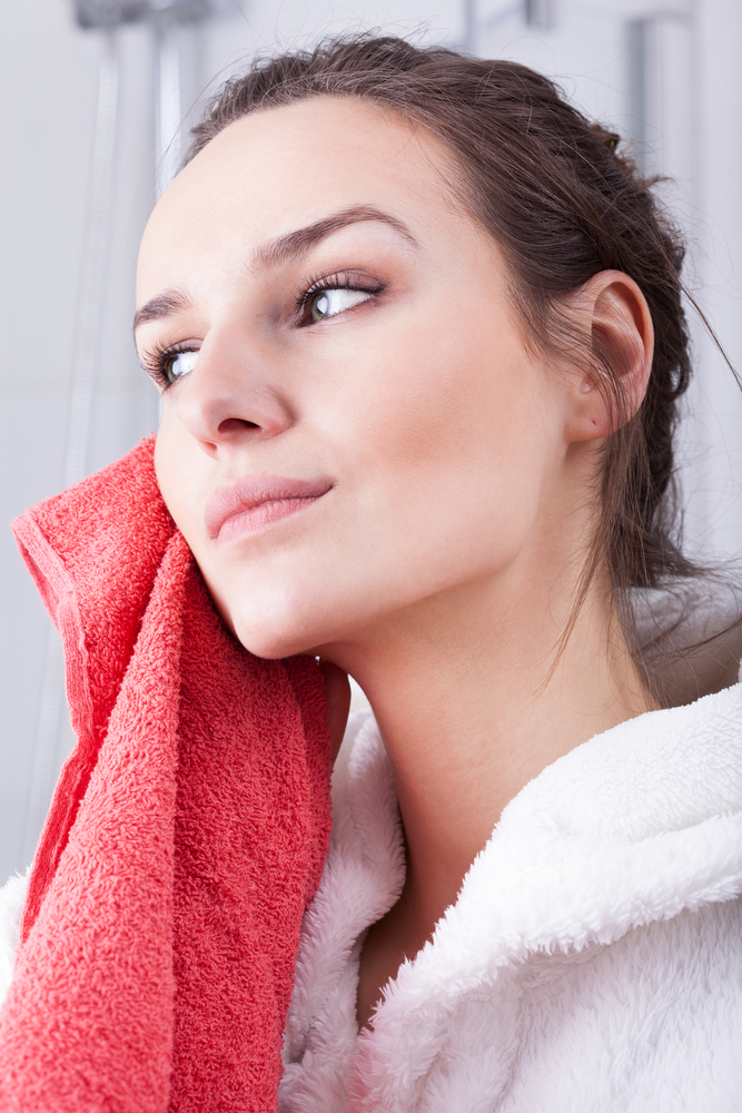 Woman cleansing face