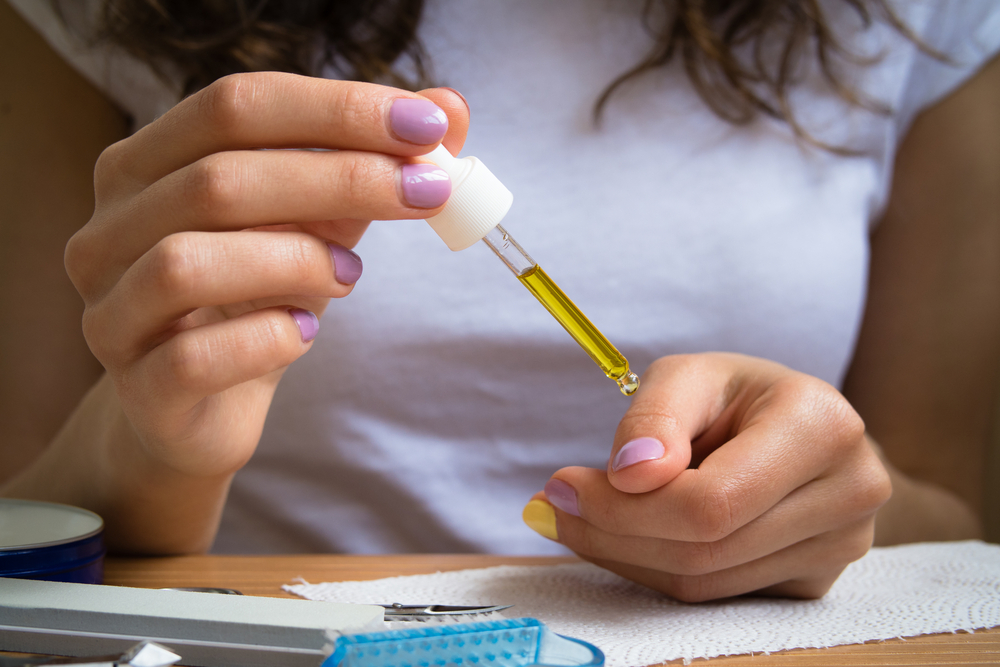 Woman applying cuticle oil