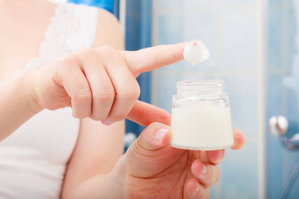 Woman applying a serum on her skin