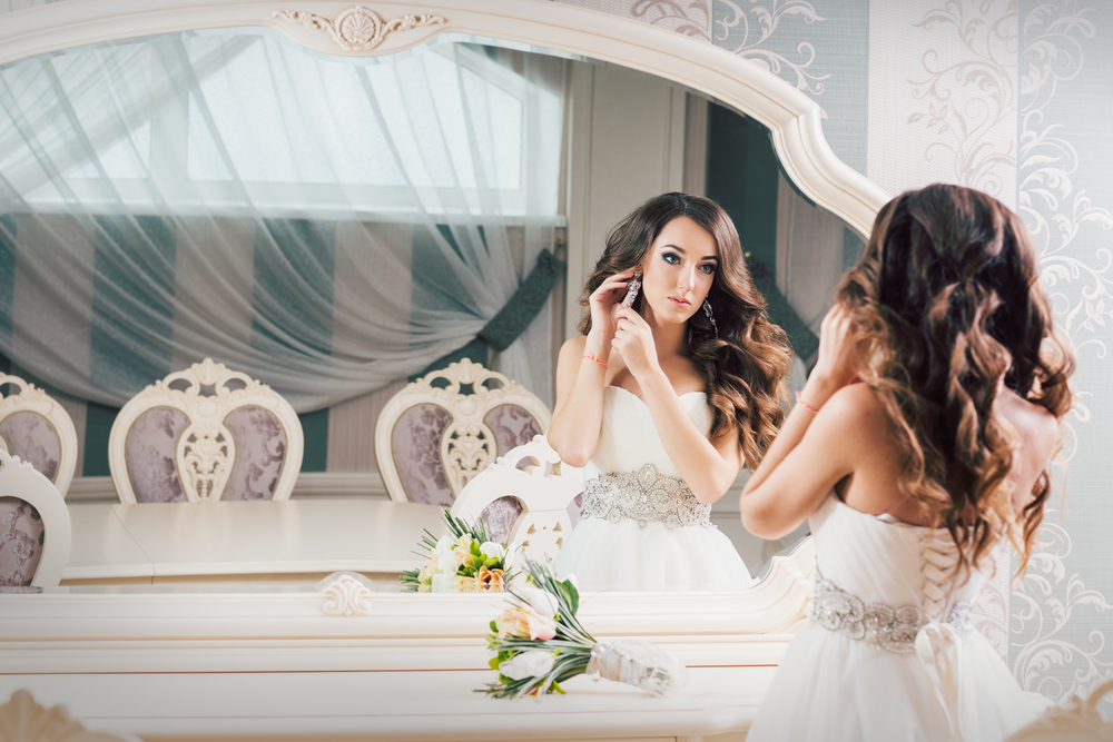 Beautiful bride getting ready in mirror