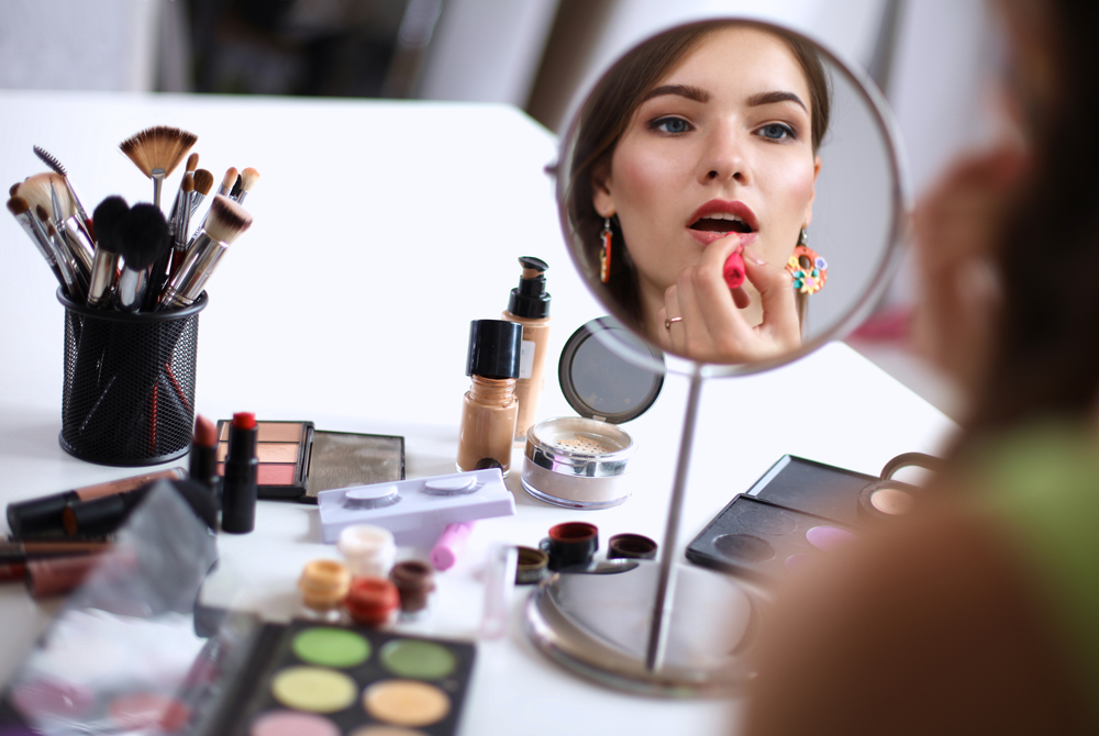 Women applying her makeup at her makeup table.