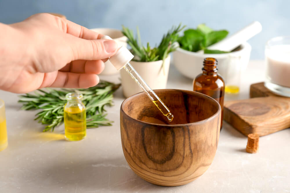 Dropper with essential oil, into a wooden bowl