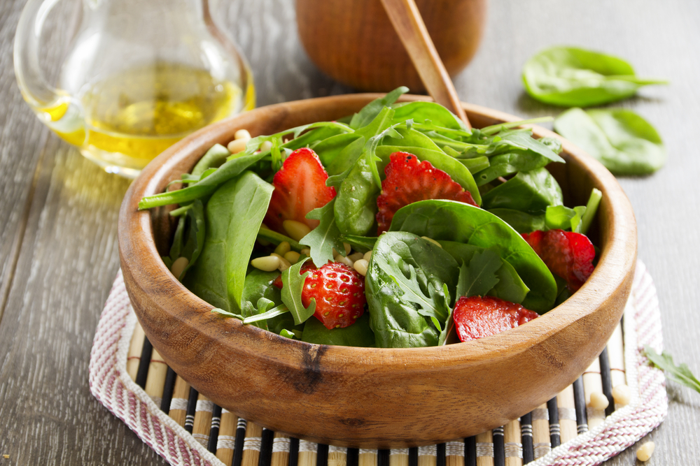 Spinach salad in wooden bowl