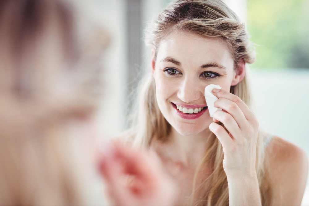 Woman removing makeup with cotton pad