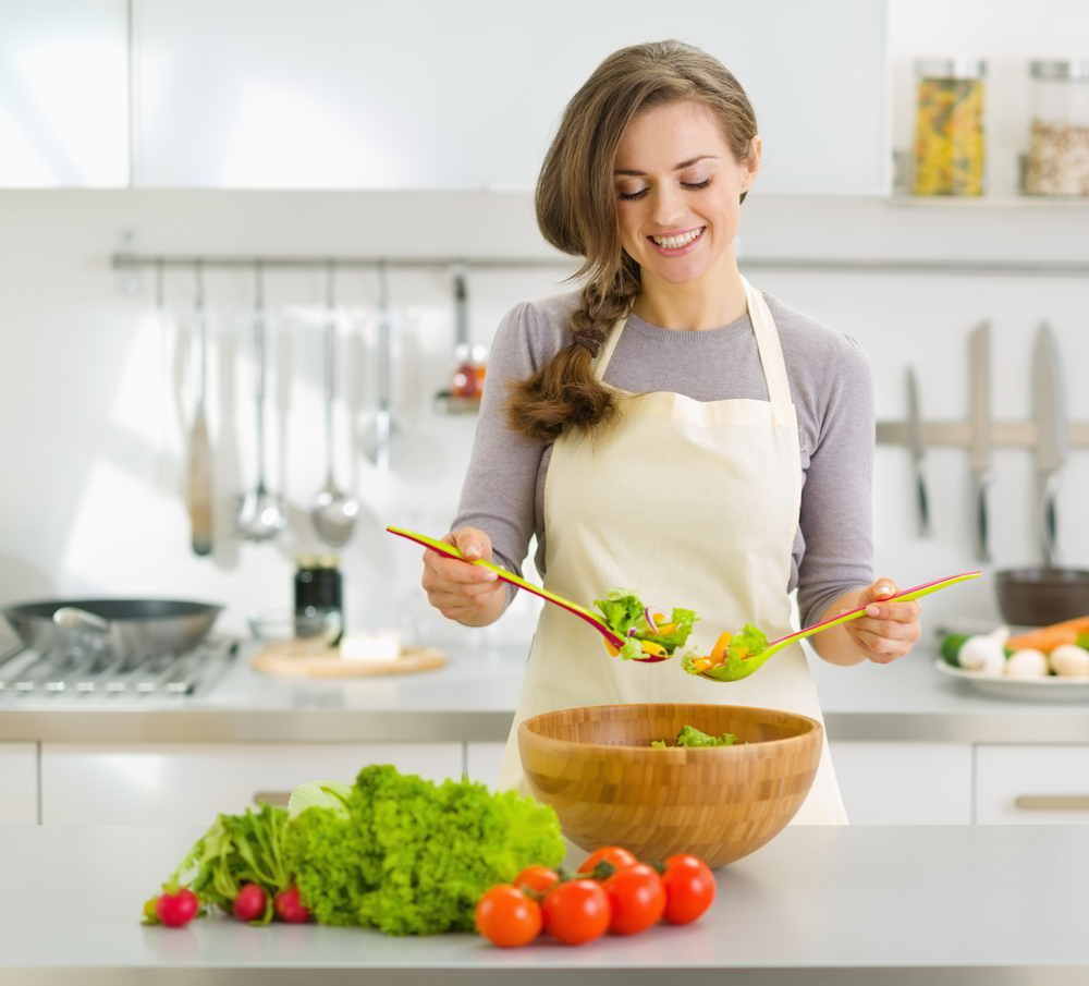 Woman making salad in kitchen