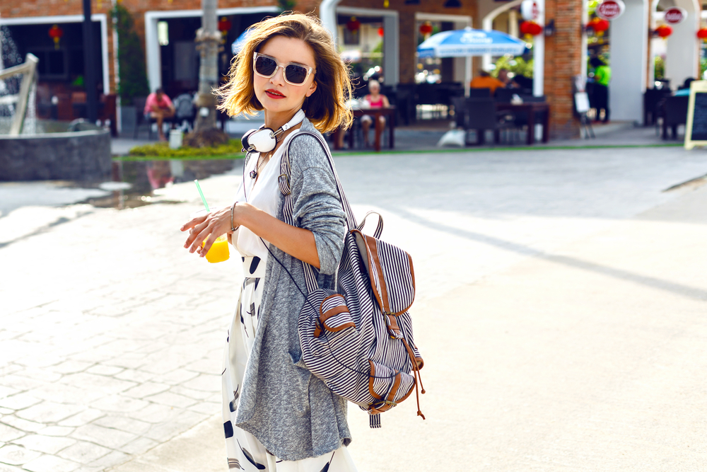 Woman with sunglasses and backpack outdoors