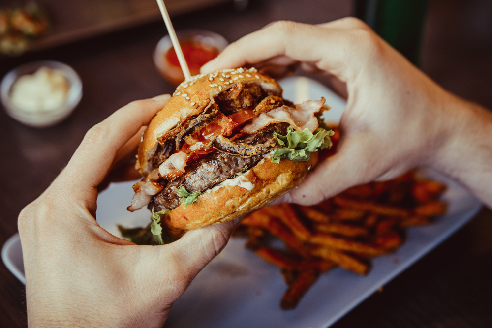 Hands holding a delicious burger