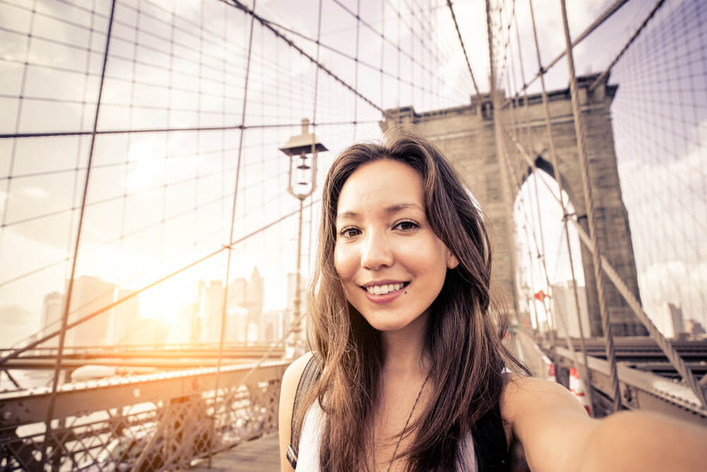 Woman taking a selfie on a bridge