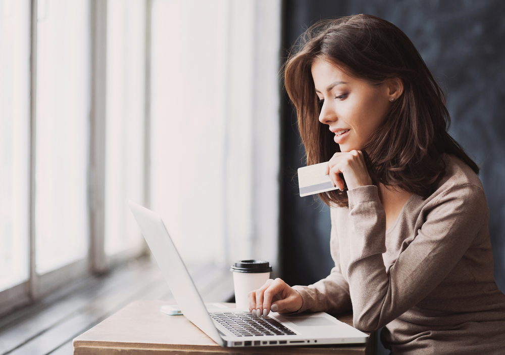 Woman shopping online, holding credit card