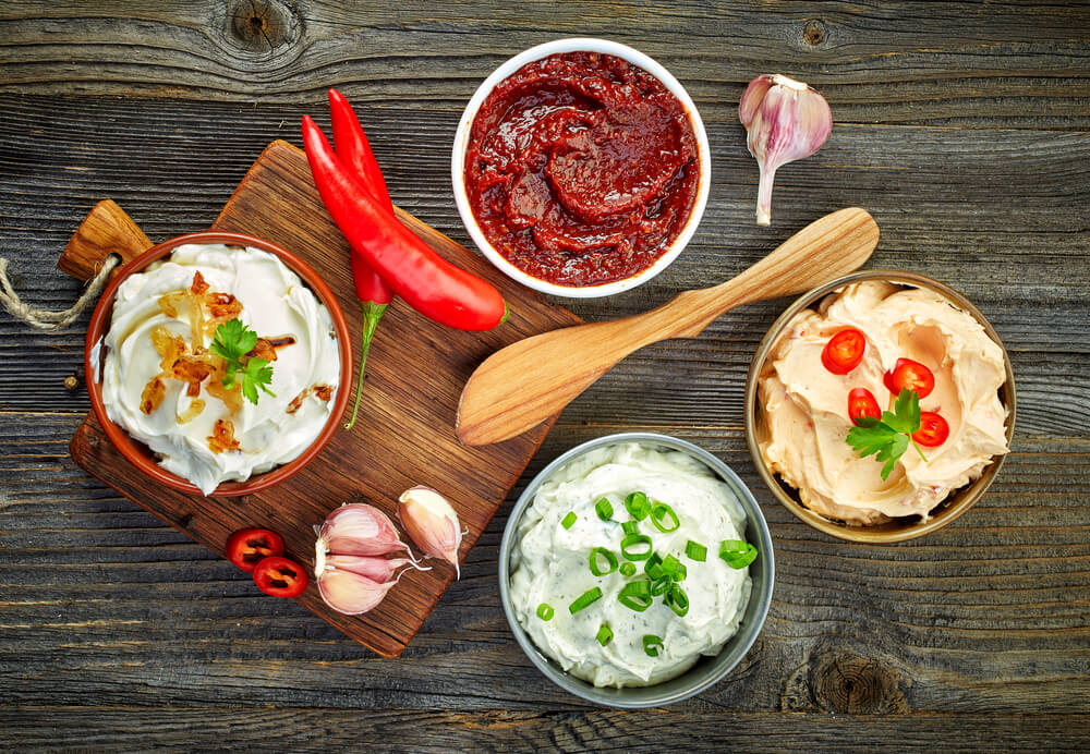 Assorted snack dips on wooden table