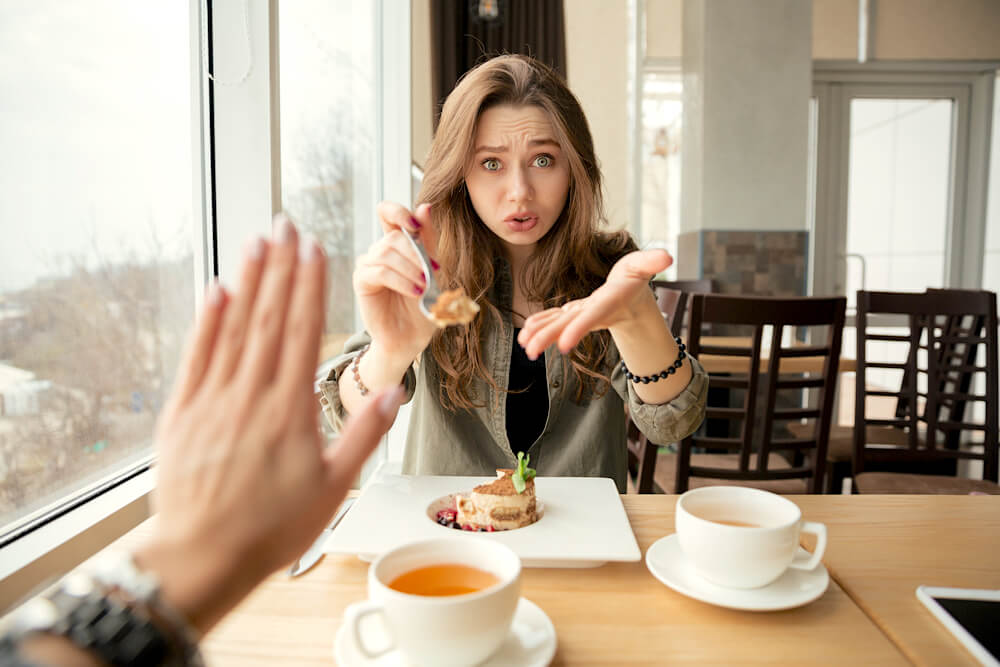 Woman offering food to picky eater