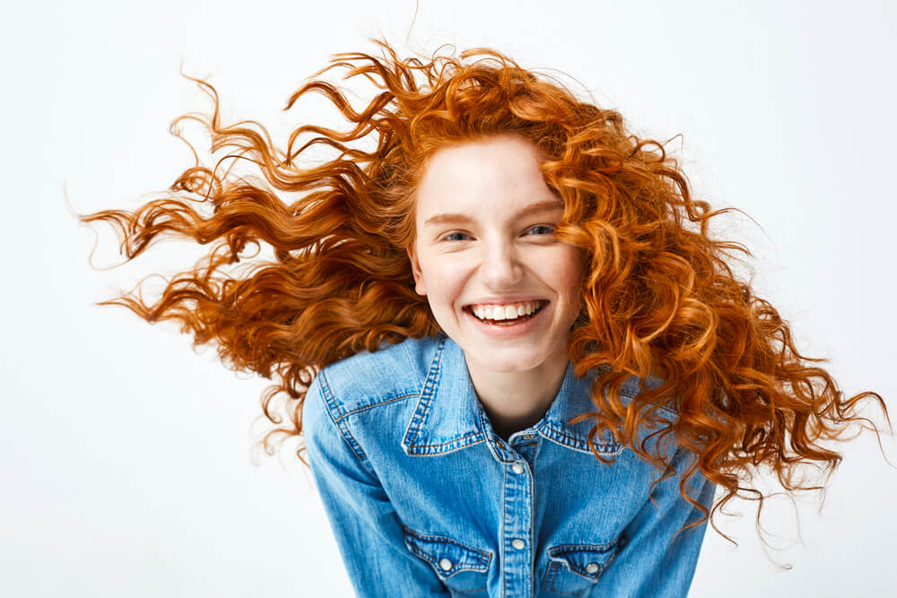 Woman with red curly hair smiling