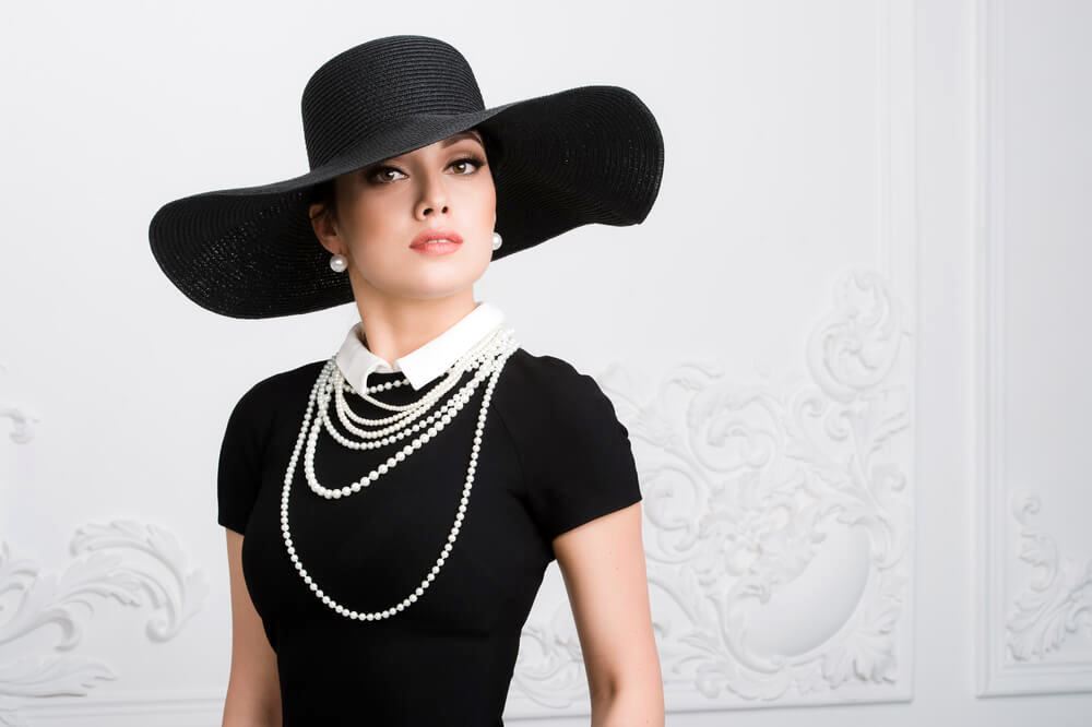 Woman with black hat and pearls