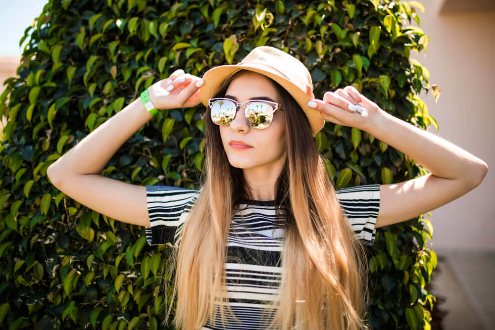 Woman with hat and sunglasses in the sun