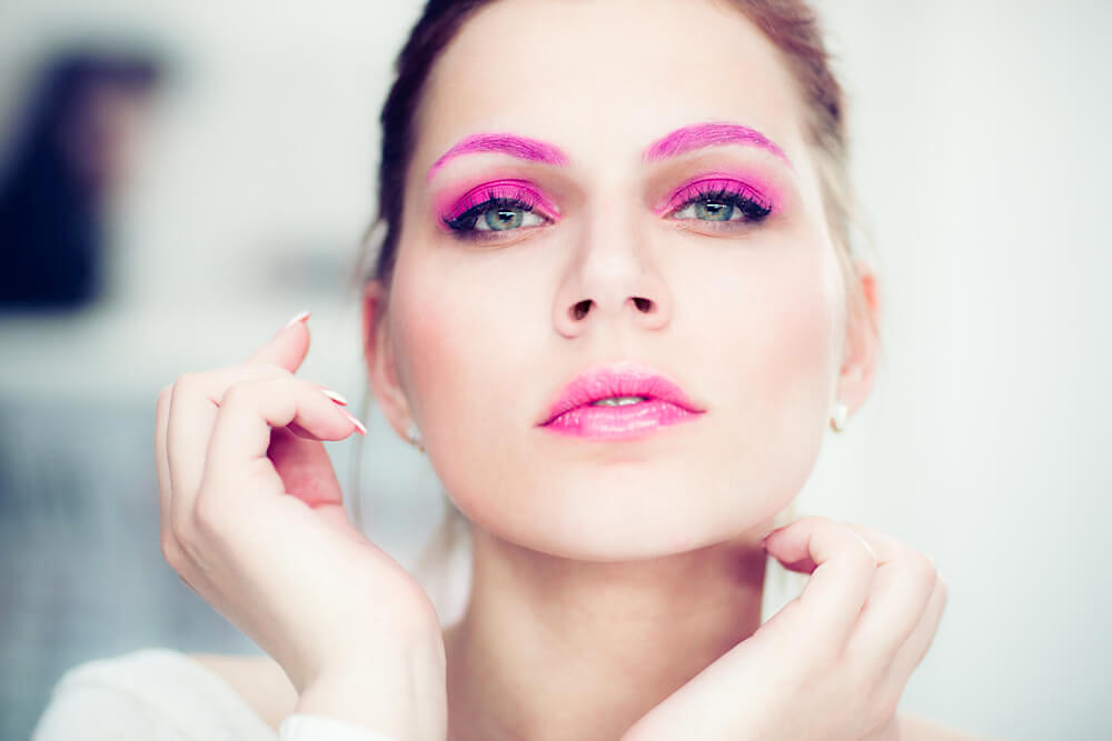 Young woman with bright pink eyeshadow and eyebrows