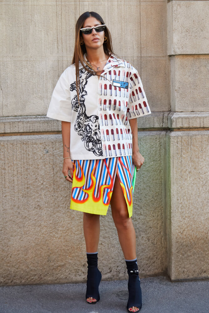 MILAN - JUNE 17: Gilda Ambrosio with white Prada shirt with lipstick decoration and skirt with flames before Prada fashion show, Milan Fashion Week street style on June 17, 2018 in Milan.