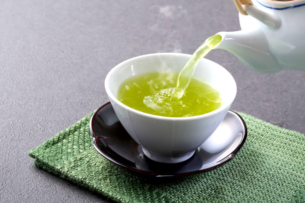 Pouring green tea into small cup