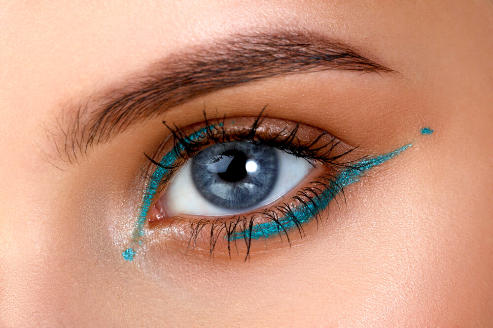 Closeup of woman's eye with blue eyeliner