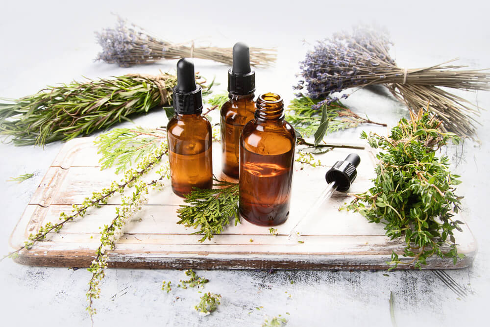 Essential oils in small bottles, surrounded by loose lavender