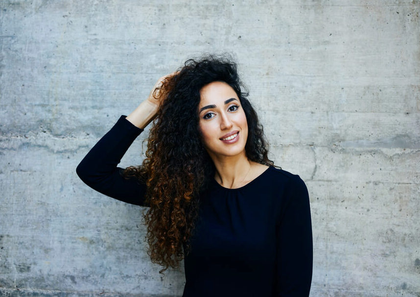 Young woman smiling and touching her curly long hair