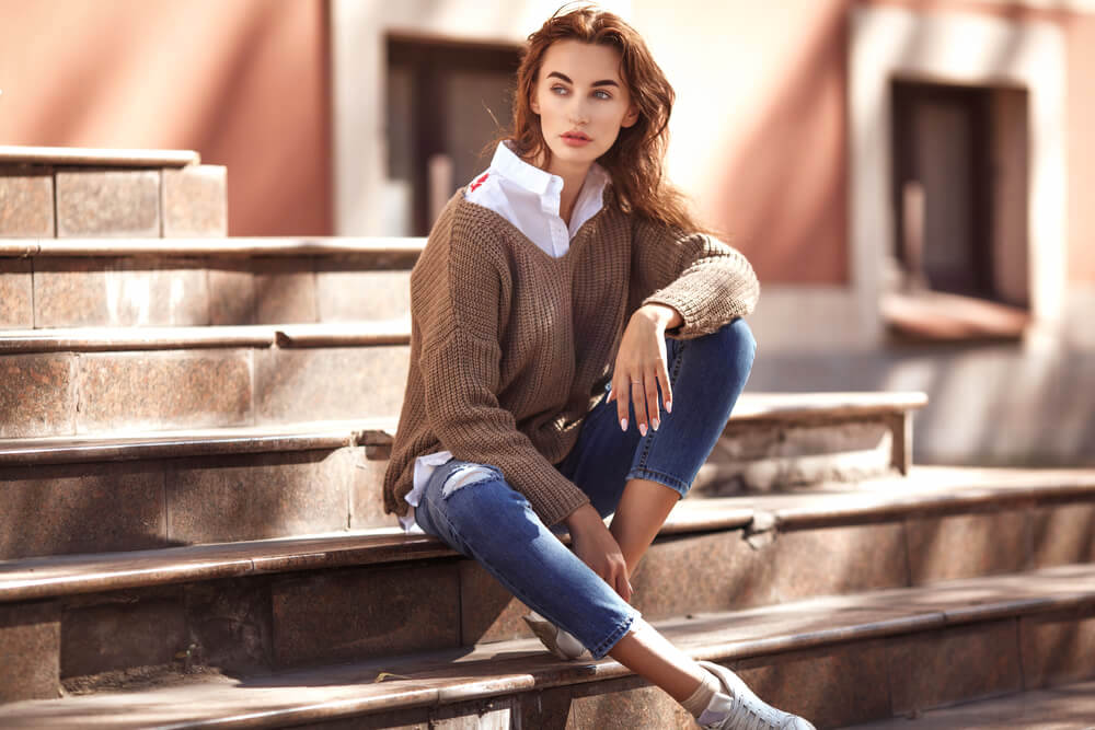 Fashionable woman sitting on outdoor steps