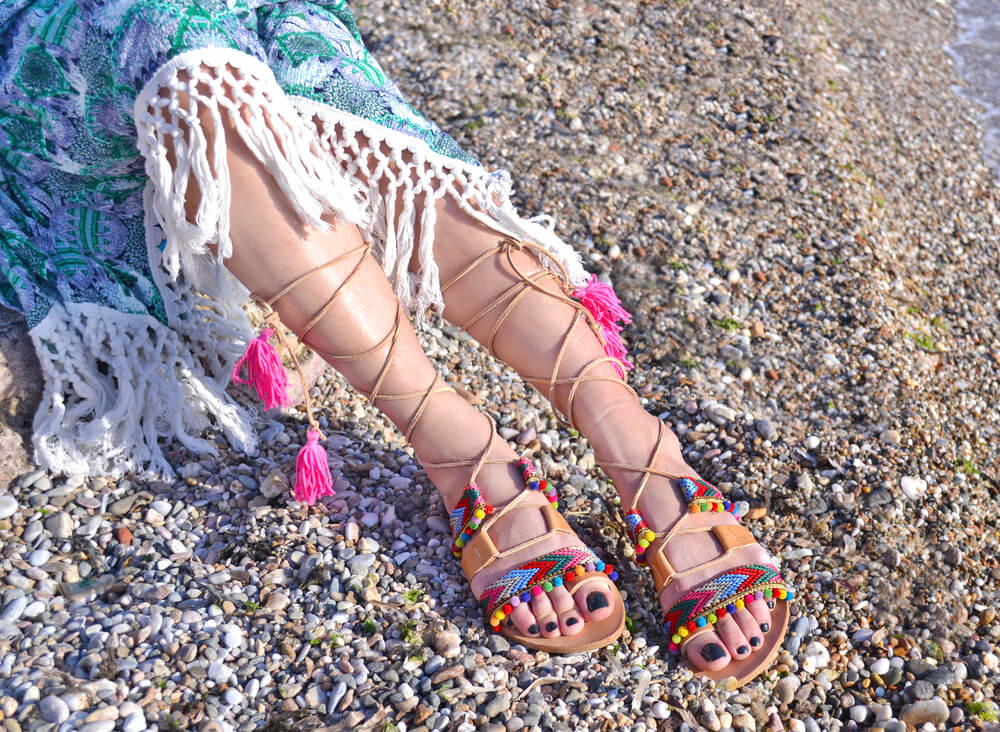 Female feet in sandals at the beach