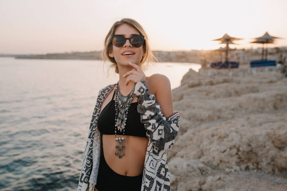 Young bohemian woman in sunglasses at the beach