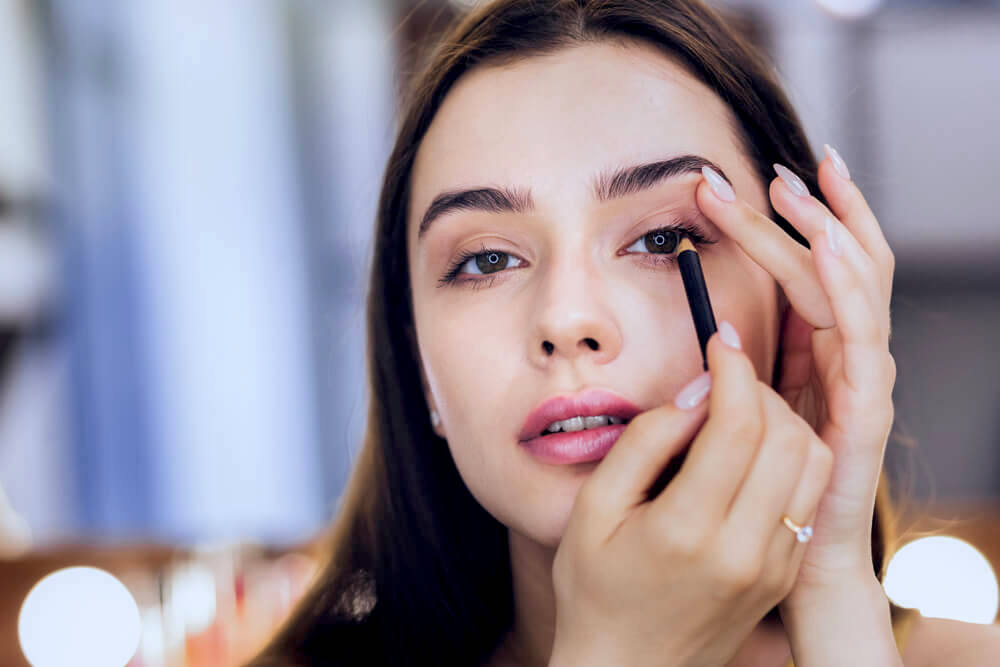 Woman applying black eyeliner