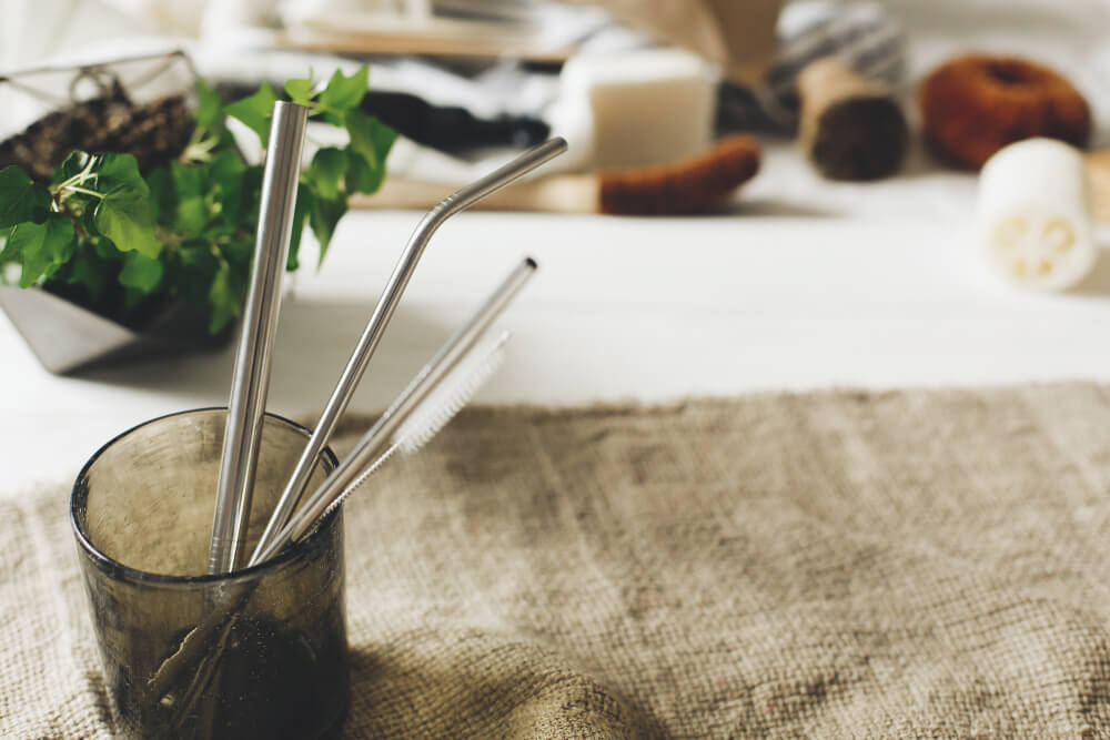 Metal straws and cleaning brush on table