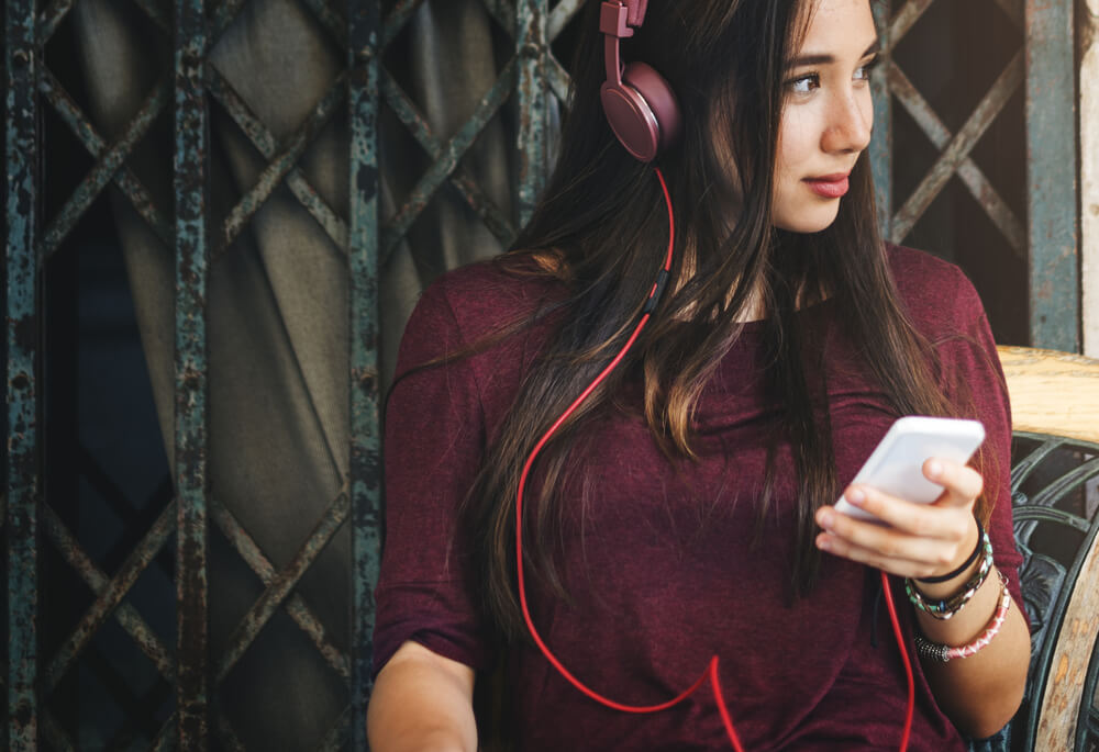 Woman with phone and headphones on