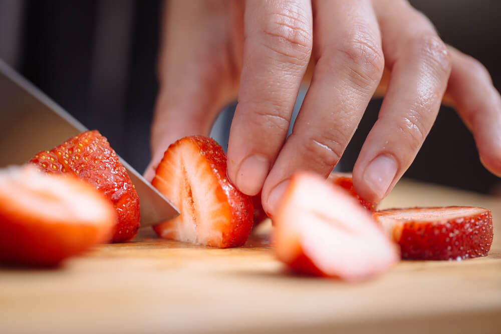 Hand cutting strawberries