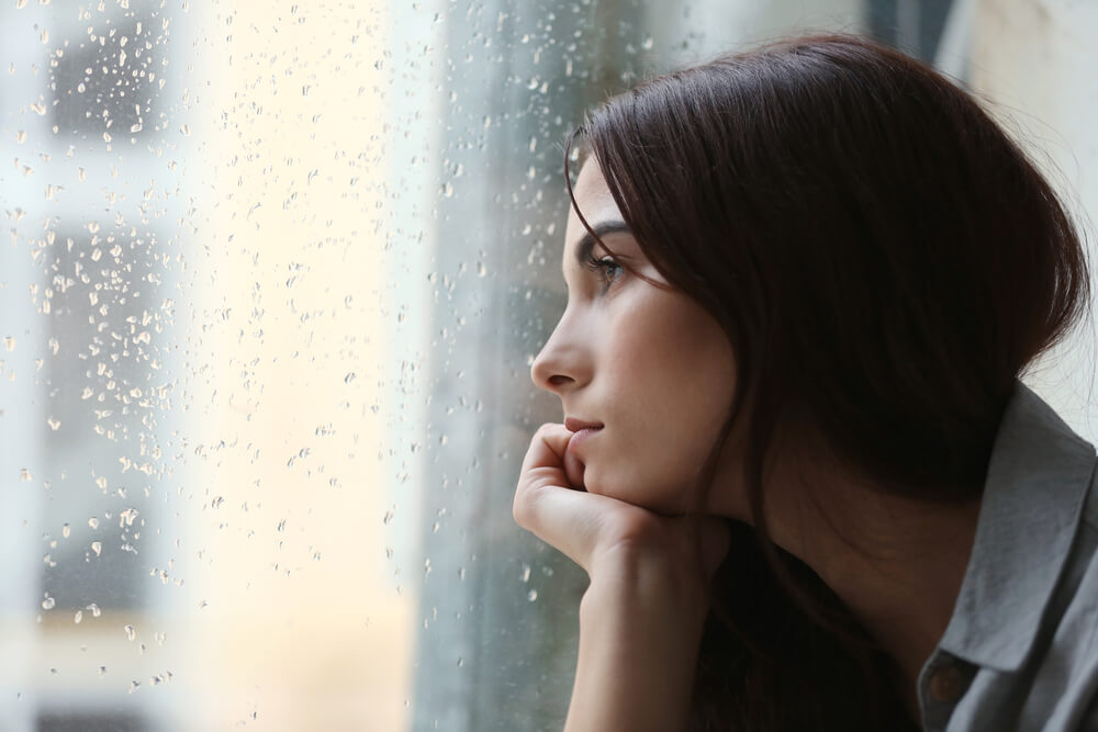 Sad woman looking out window