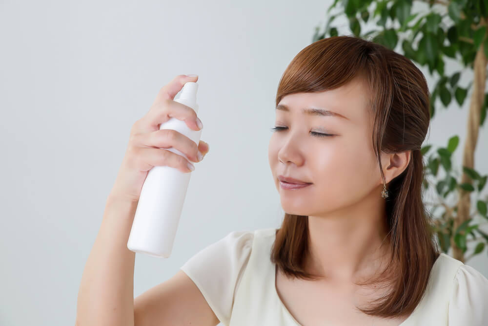 Woman applying face mist