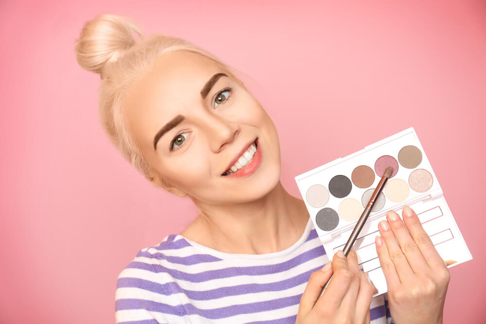 Woman pointing at pink eyeshadow