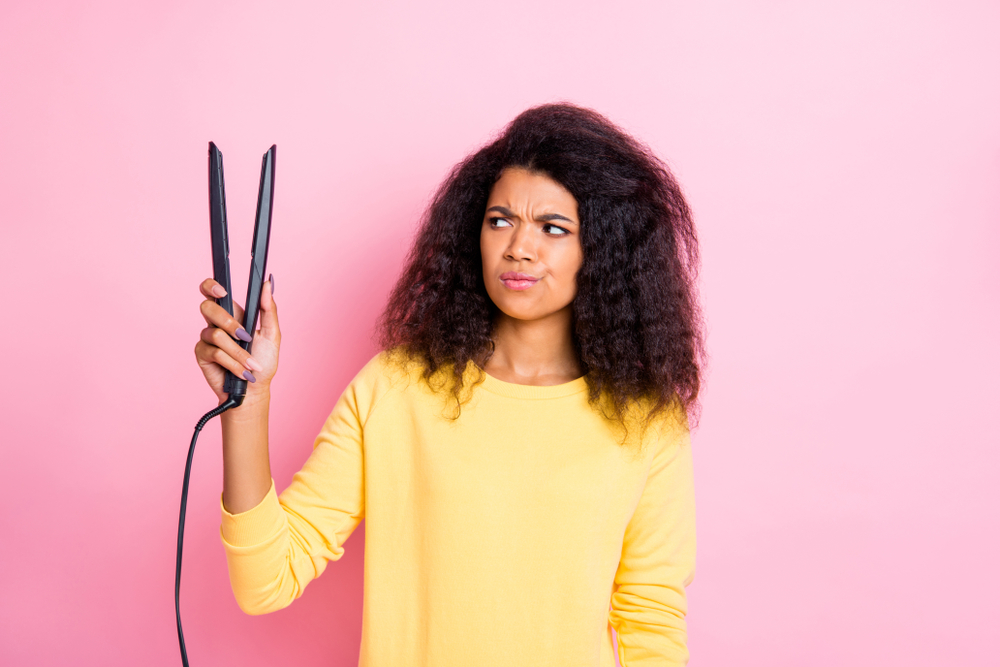 woman holding hair straightener