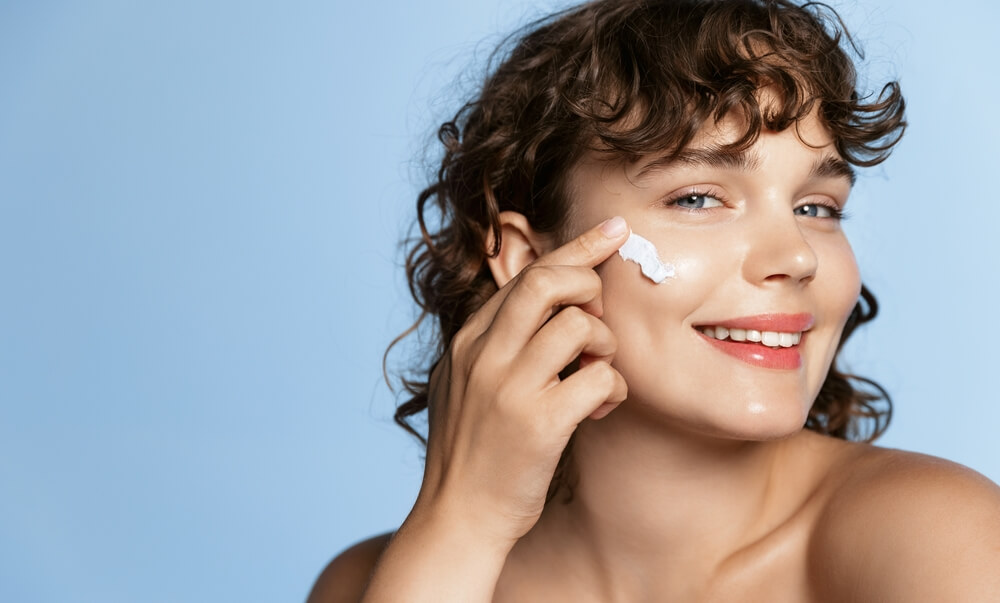 woman applying moisturizer