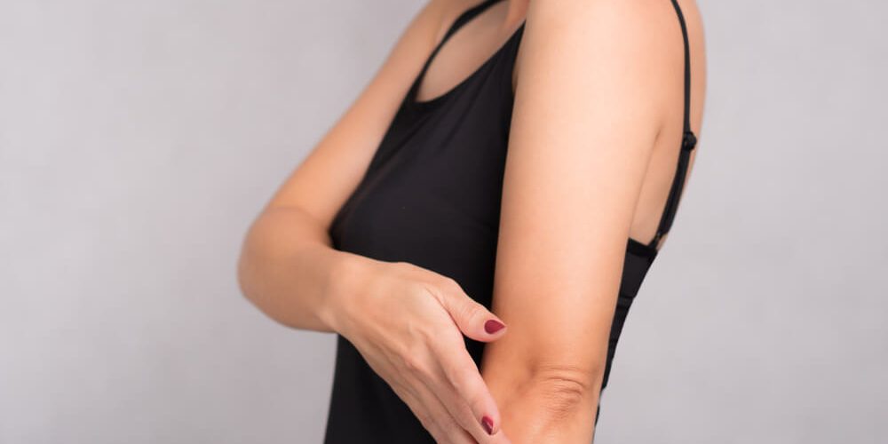 woman touching elbow